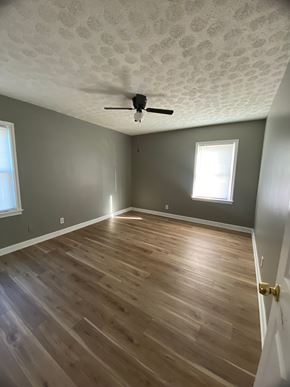 Shively apartment for rent - A room with a ceiling fan and wooden flooring.