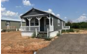 Shawnee house for rent - A small house with a porch is surrounded by a dirt field.
