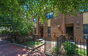 Washington apartment for rent - a brick apartment building with a yard and a wrought iron fence