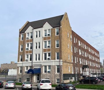 Detroit apartment for rent - a large brick building with cars parked in front of it