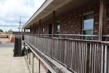 Houma apartment for rent - a building with a wooden porch and a brick wall