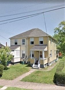 Clairton house for rent - an old yellow house with a porch and a driveway