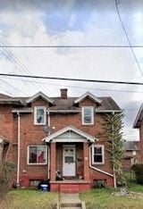 Clairton house for rent - A red brick house with a white door and a small porch.