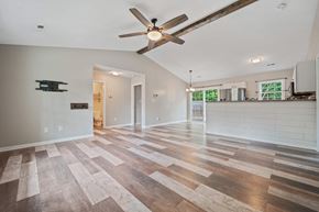 Richlands house for rent - A spacious room with a ceiling fan and wooden flooring.