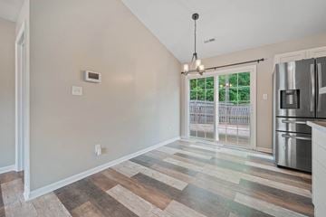 Richlands house for rent - A kitchen with a refrigerator and a window with a view of a fence and trees.