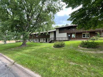 Menomonie apartment for rent - the front of a house with a lawn and trees