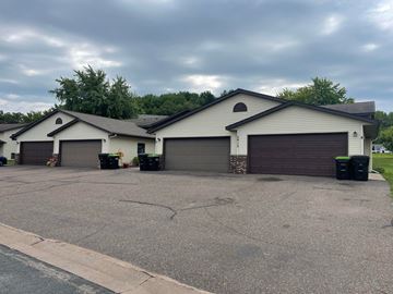Menomonie apartment for rent - a white house with two garage doors and a driveway