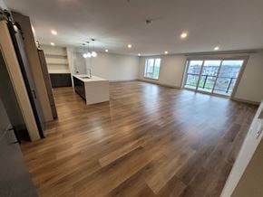 Bedford apartment for rent - A spacious room with wooden flooring and a large window.