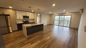 Bedford apartment for rent - A modern kitchen with a wooden floor and a large island.