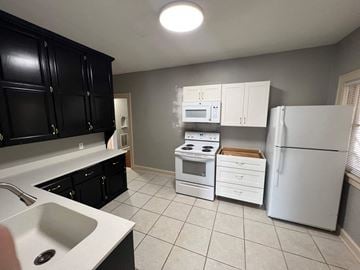 Omaha apartment for rent - a kitchen with white appliances and black cabinets