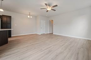 Jacksonville house for rent - A spacious room with a ceiling fan and light fixture.