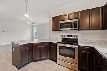Jacksonville house for rent - A kitchen with dark wood cabinets and stainless steel appliances.