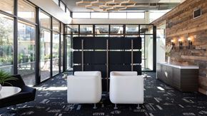 Austin apartment for rent - A co-working space with black chairs and a wooden wall.