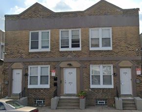 Philadelphia apartment for rent - A three-story brick building with white doors and windows.