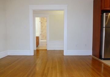 San Francisco apartment for rent - A kitchen with a refrigerator on the right and a doorway leading to another room.
