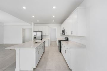Estero house for rent - a large white kitchen with white counters and white cabinets
