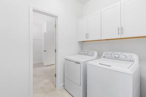 Estero house for rent - a white laundry room with white appliances and white cabinets
