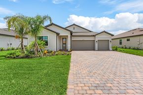Estero house for rent - A house with a driveway and a tree in front.