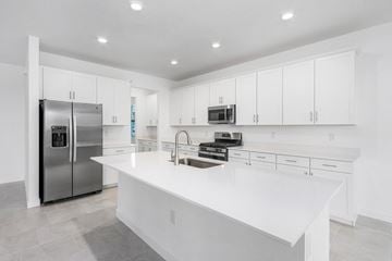 Estero house for rent - A modern kitchen with white cabinets and a large island.