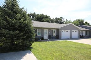 Dell Rapids apartment for rent - A house with a grey roof and white garage doors.