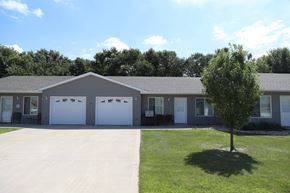 Dell Rapids apartment for rent - A building with a grey roof and white garage doors.