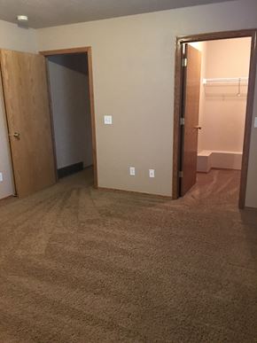 Dell Rapids apartment for rent - A room with carpeted floor and two open doors.