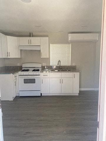 Riverside apartment for rent - a kitchen with white cabinets and a stove and a sink
