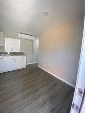 Riverside apartment for rent - an empty living room and kitchen with a wood floor