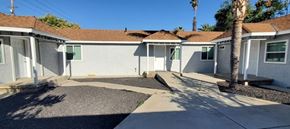 Riverside apartment for rent - a white house with a sidewalk and palm trees