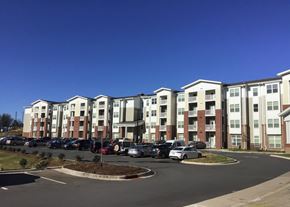 Charlotte apartment for rent - a large apartment building with cars parked in a parking lot