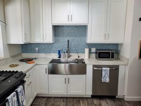 Imperial Beach house for rent - a kitchen with white cabinets and a stainless steel sink