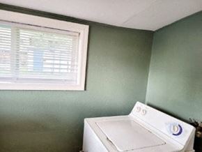 Anchorage apartment for rent - A white washing machine sits in a room with green walls.