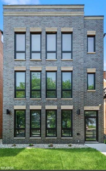 Chicago apartment for rent - a brick building with windows and grass in front