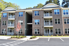 Clinton apartment for rent - A large brick apartment building with a parking lot in front.