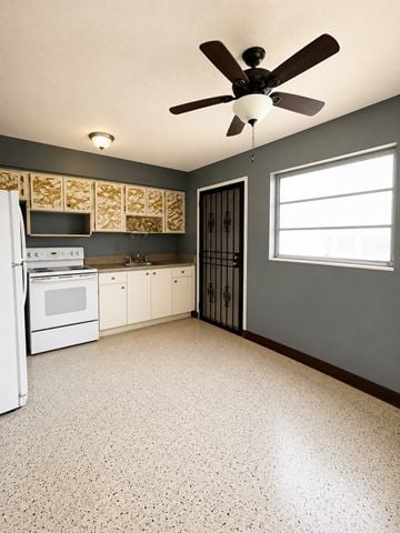 Miami apartment for rent - A kitchen with a white refrigerator and a ceiling fan.