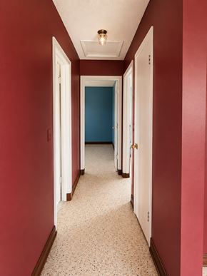 Miami apartment for rent - A hallway with red walls and white doors.