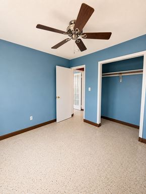 Miami apartment for rent - A room with a ceiling fan and a door.