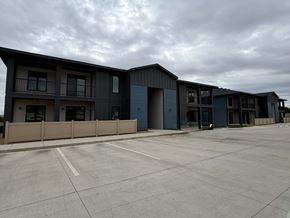 Dodge City apartment for rent - A parking lot in front of a building with grey and blue exterior.