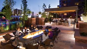 Denver apartment for rent - a rendering of the patio at night with people sitting around a fire pit