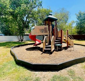 Pasadena apartment for rent - A playground with a red slide and a wooden play structure.