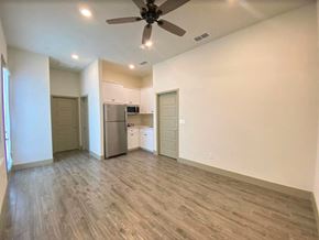 Merced house for rent - an empty living room with a kitchen and a ceiling fan