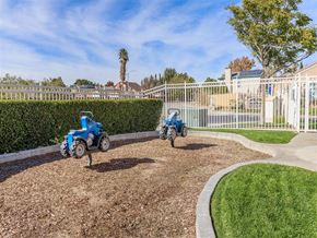 Rosamond apartment for rent - two toy cars in the mulch playground in front of a white fence