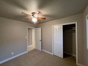Fort Collins apartment for rent - A room with a ceiling fan and three doors.