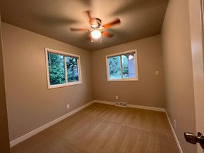 Fort Collins apartment for rent - A room with a ceiling fan and two windows.