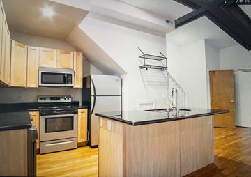 Columbus apartment for rent - a kitchen with wooden cabinets and a black counter top