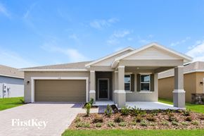 Kissimmee house for rent - A modern house with a garage door and a front yard.