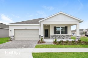 Kissimmee house for rent - a white house with a driveway and a garage door