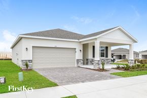 Kissimmee house for rent - a white house with a driveway and a garage door