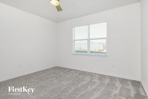 Kissimmee house for rent - a bedroom with white walls and carpet and a window