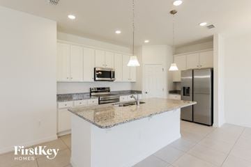 Bartow house for rent - a kitchen with white cabinets and a granite counter top